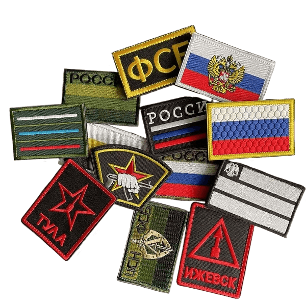A pile of tactical and military embroidered patches, including flags and unit insignia